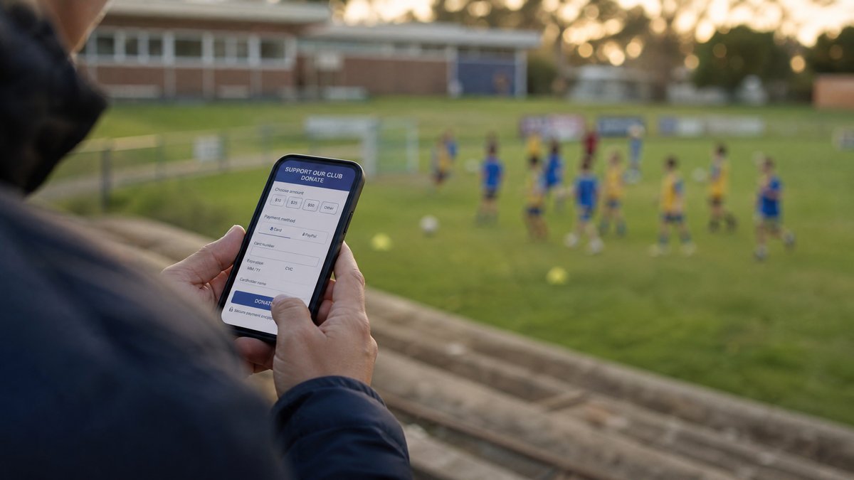 Osoba donira sportskom klubu putem kartice na mobilnom telefonu - sigurno plaćanje Monri